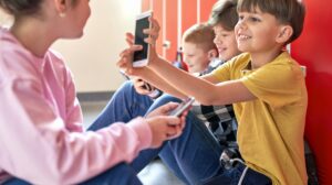 dzieci ze smartfonami w szkole