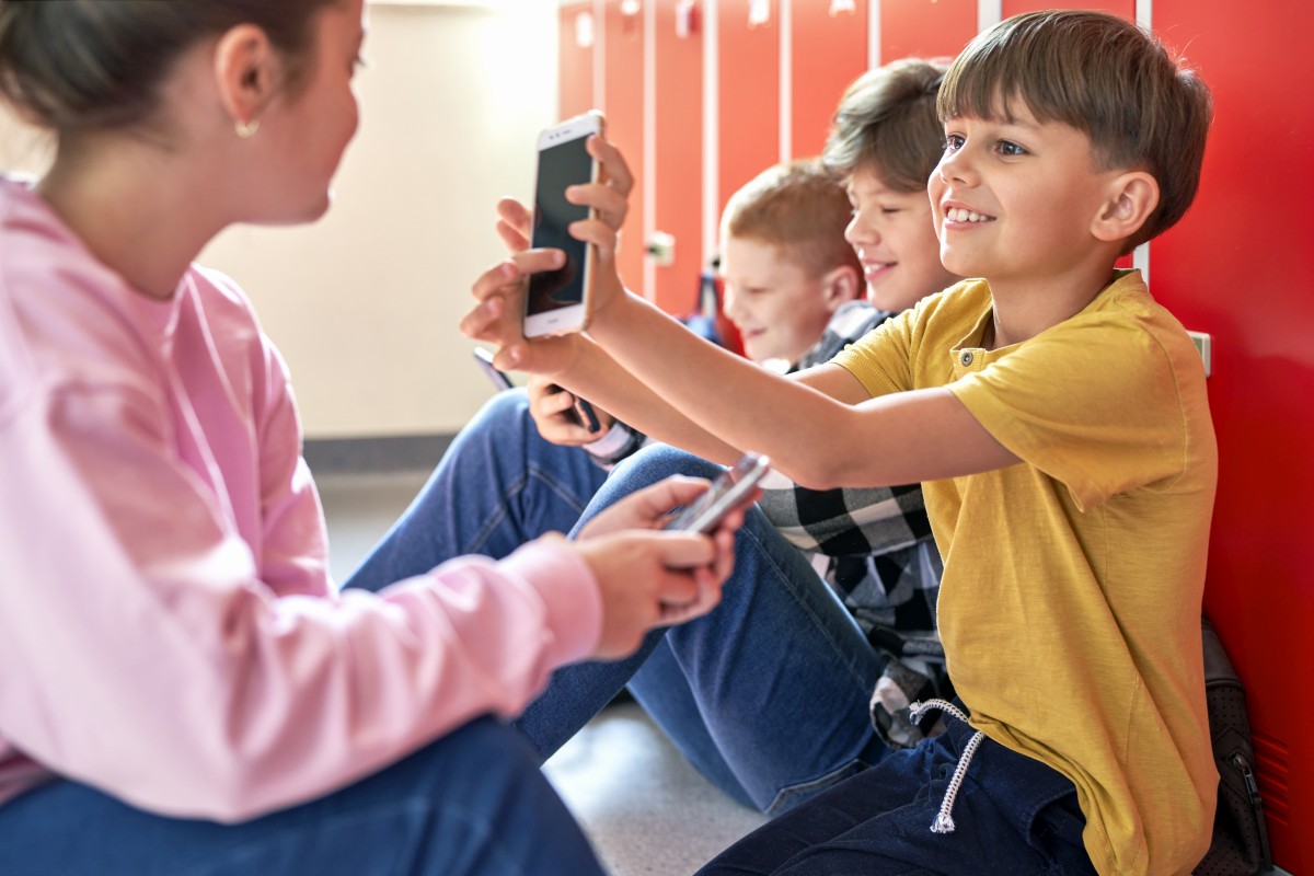 dzieci ze smartfonami w szkole